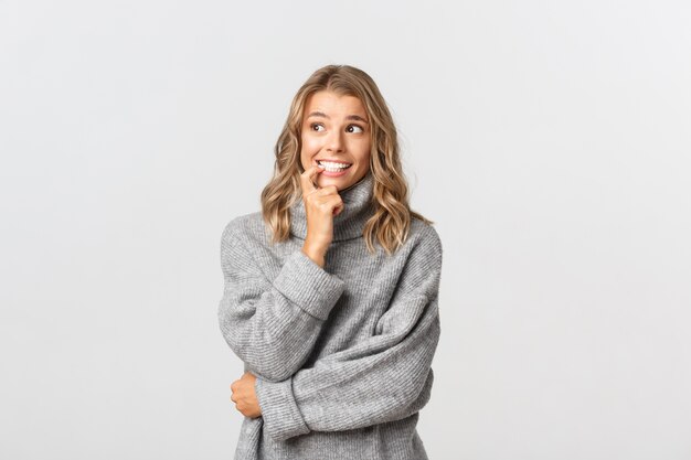 Hermosa mujer en un suéter gris posando