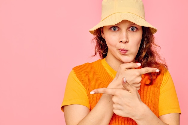 Hermosa mujer suéter naranja emociones diversión fondo rosa inalterado