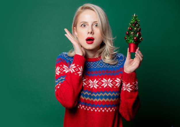 Hermosa mujer en suéter de Navidad con árbol de Navidad