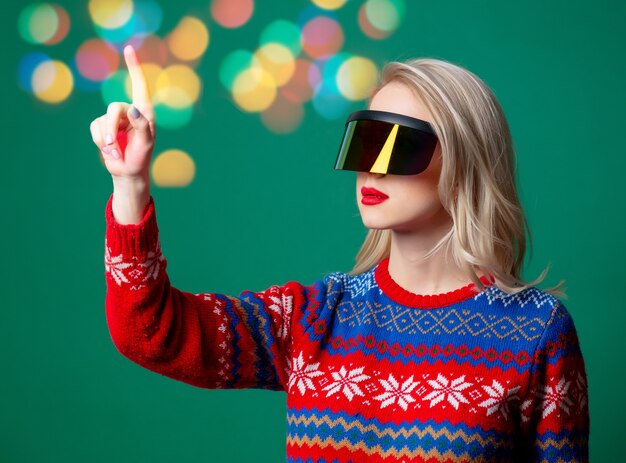 Hermosa mujer en suéter de Navidad y gafas Vr