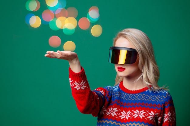 Hermosa mujer en suéter de Navidad y gafas Vr