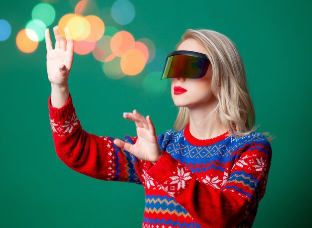 Hermosa mujer en suéter de Navidad y gafas Vr