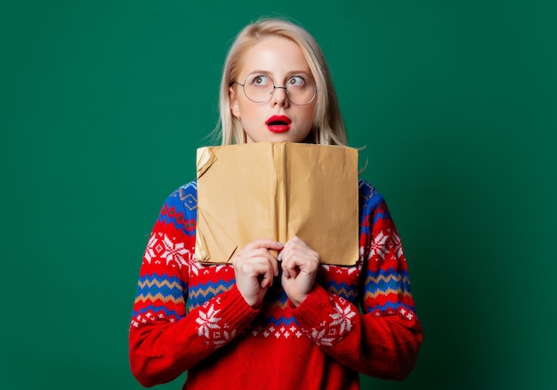 Hermosa mujer en suéter de Navidad con un libro