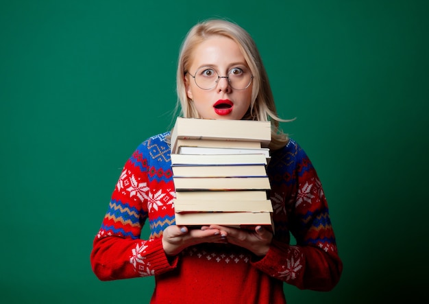 Hermosa mujer en suéter de Navidad con libros