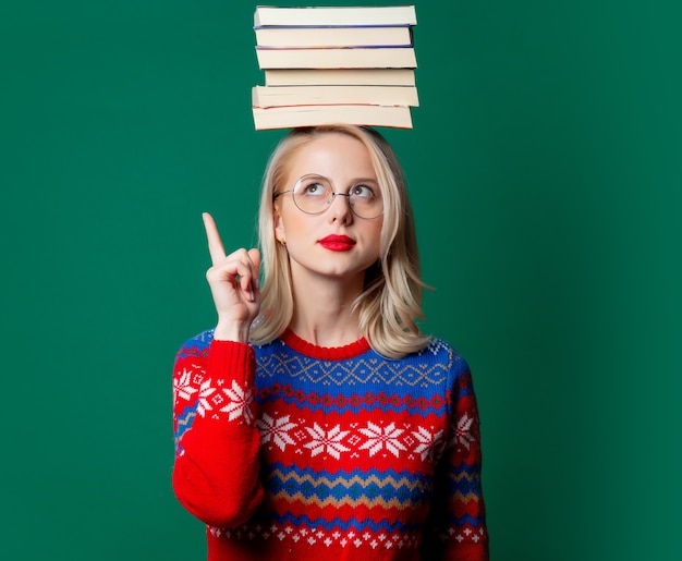 Hermosa mujer en suéter de Navidad con libros