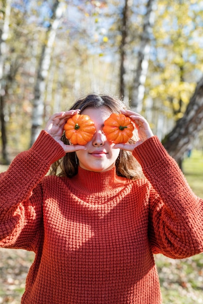 Foto hermosa mujer en suéter rojo en un picnic en un bosque de otoño