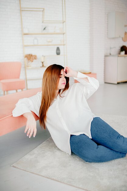 Hermosa mujer de talla grande modelo vestida con camisa blanca en blanco posando