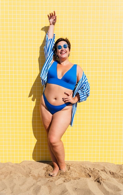 Foto hermosa mujer de talla grande con traje de baño en la playa