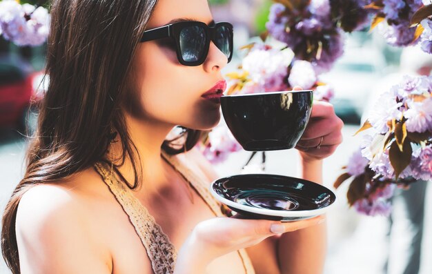 Hermosa mujer en una taza de café espresso con café con leche o capuchino para el pedido del cliente en