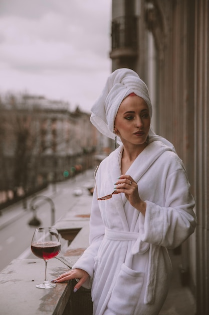 Foto hermosa mujer en una toalla de baño blanca y gafas de sol mirando a otro lado