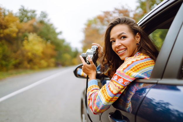 Foto hermosa mujer toma fotos en la cámara desde la ventana del auto concepto de estilo de vida de relajación de descanso