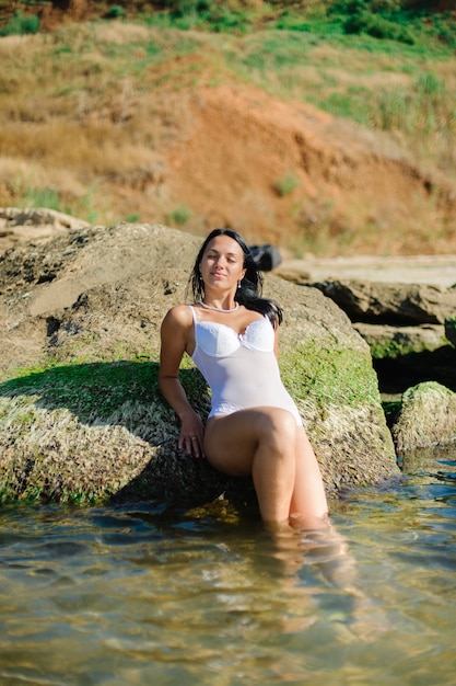 Hermosa mujer tomando el sol en la orilla del mar.