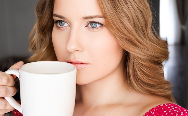 Hermosa mujer tomando una taza de té por la mañana en casa