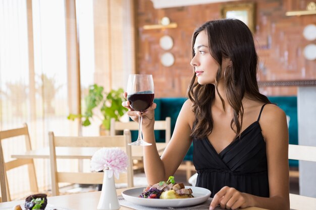 Foto hermosa mujer tomando vino con comida