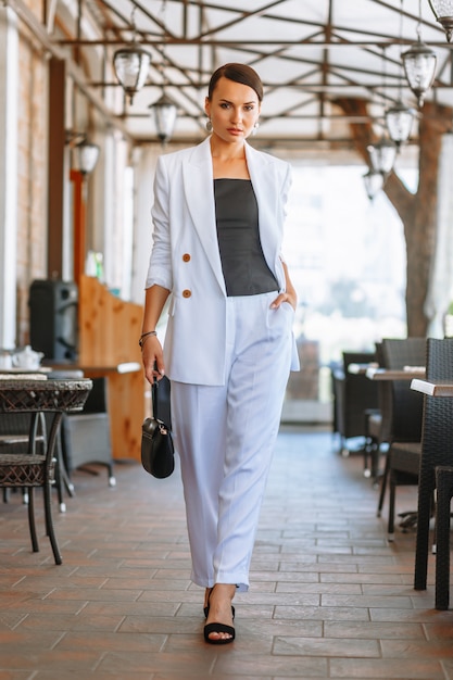 Hermosa mujer en un traje blanco en un restaurante