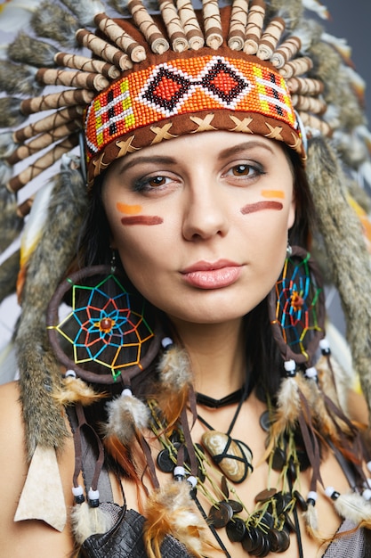 Foto hermosa mujer en traje de nativos americanos con plumas