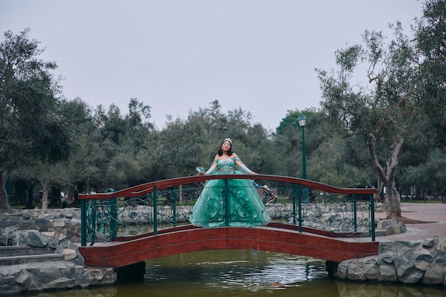 Hermosa mujer en traje de princesa vestido de bola en un puente