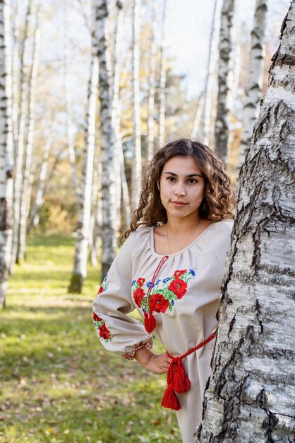 Hermosa mujer en traje tradicional nacional ucraniano en el bosque