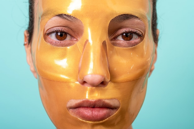 Hermosa mujer con tratamiento de mascarilla facial de gel de colágeno para el cuidado de la piel