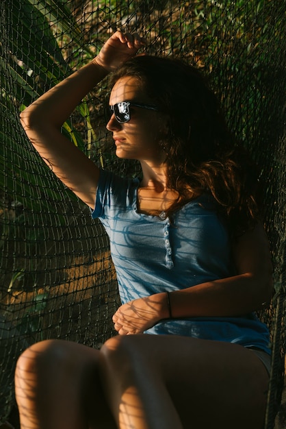 Hermosa mujer tumbada en una hamaca cerca del océano.