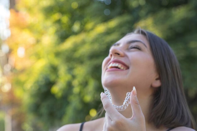 Hermosa mujer turca sonriente sostiene un brazalete invisalign