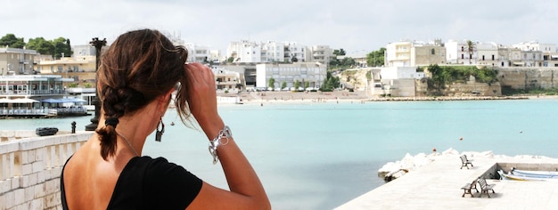 Foto hermosa mujer turista admira el puerto histórico de otranto apulia italia