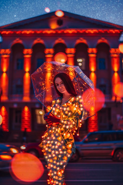 Hermosa mujer con umrella en ciudad de noche