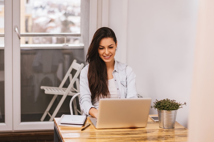 Foto hermosa mujer usando laptop en casa