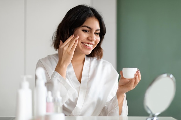 Foto hermosa mujer usando nuevo cosmético en casa copiar espacio