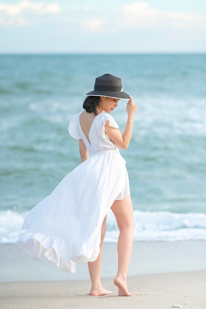 Hermosa mujer vestida de blanco en la playa