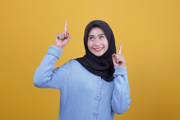 Hermosa mujer vestida con hijab con expresión feliz mirando hacia arriba