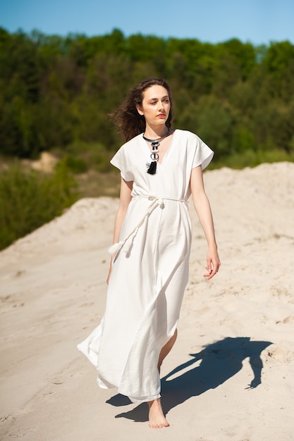 Hermosa mujer vestida con ropa de verano en la playa