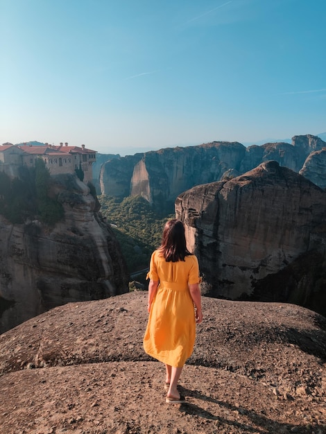 Hermosa mujer en vestido amarillo en las montañas de grecia tesalia