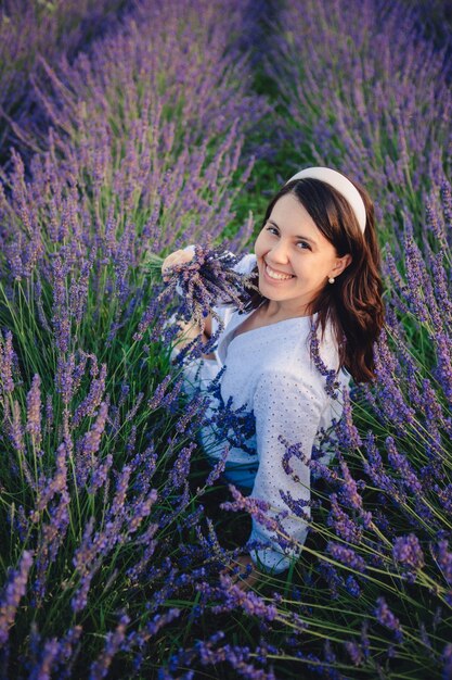 Hermosa mujer con vestido blanco en el campo de lavanda