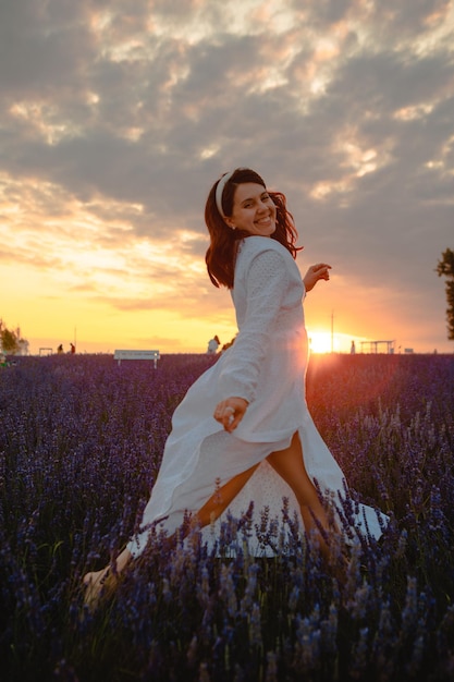 Hermosa mujer con vestido blanco en el campo de lavanda