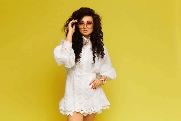 Hermosa mujer con un vestido blanco con gafas de sol