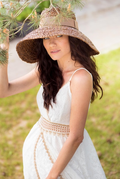 Hermosa mujer con vestido blanco de verano y sombrero de paja