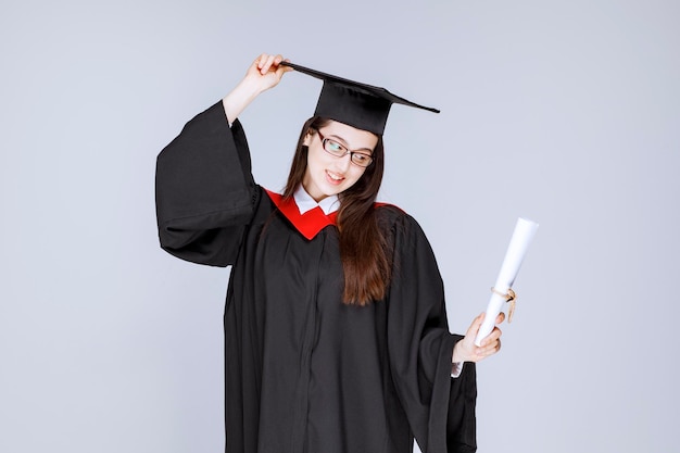 Hermosa mujer en vestido con diploma de graduación de la universidad. Foto de alta calidad