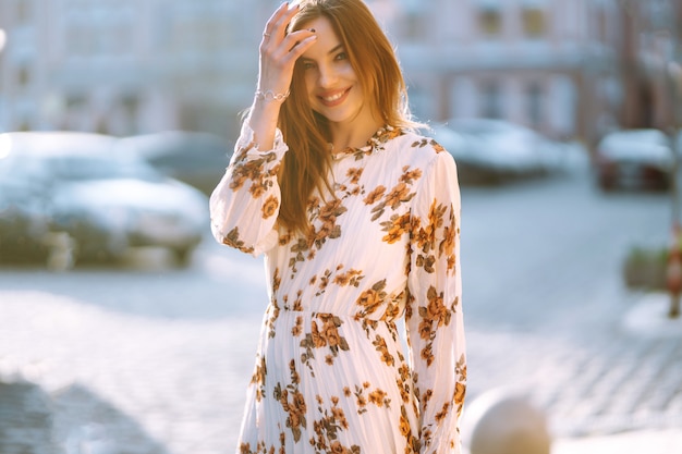 Hermosa mujer con vestido de flores posando al aire libre. Concepto de moda callejera. Mujer belleza. Vista casual