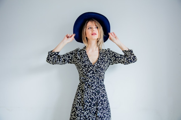 Hermosa mujer en vestido de moda y sombrero