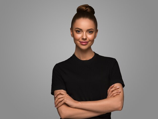 Hermosa mujer con vestido negro de manos peinado bob clásico sobre fondo de color gris