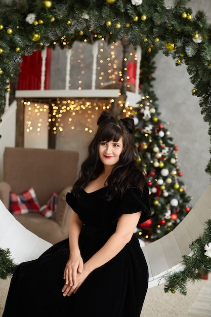 Hermosa mujer con un vestido negro en Navidad