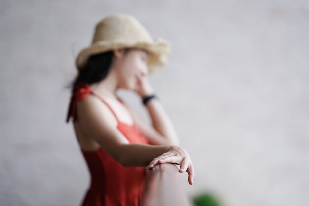 Hermosa mujer en vestido de pie en la mano de foco de balcón