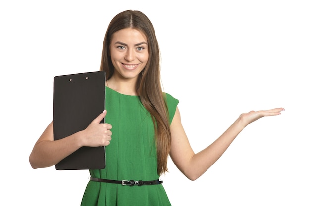 Hermosa mujer en vestido verde con portapapeles sobre fondo blanco.