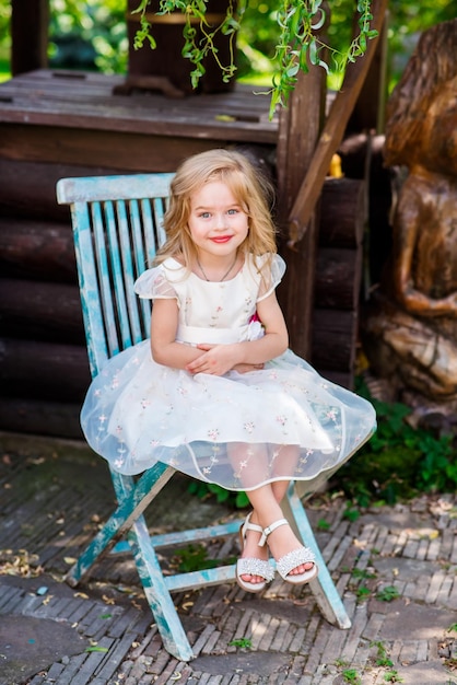 Hermosa muñeca joven con un vestido rosa en una habitación luminosa y flores sentada en una silla con una taza de té lolita Moda callejera japonesa Retrato