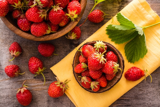 Hermosa naturaleza muerta con fresas en cuencos de madera. Vista superior