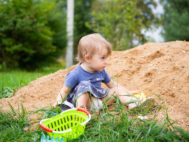 Hermosa niña de un año jugando en el arenero