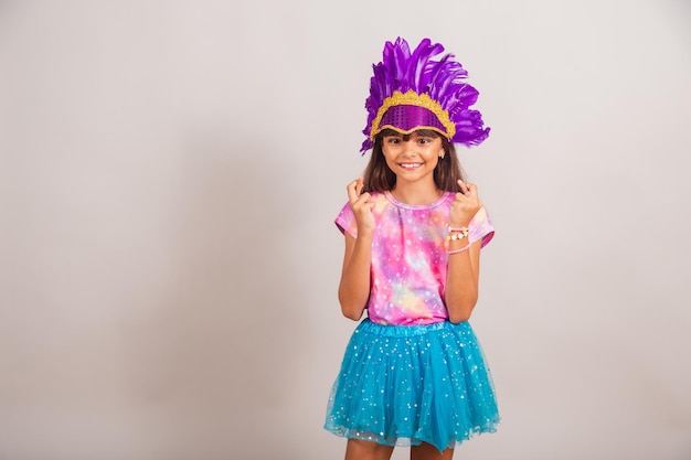 Hermosa niña brasileña vestida para el carnaval en Brasil animando duro deseando suerte