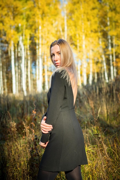 Una hermosa niña camina en un parque de otoño.