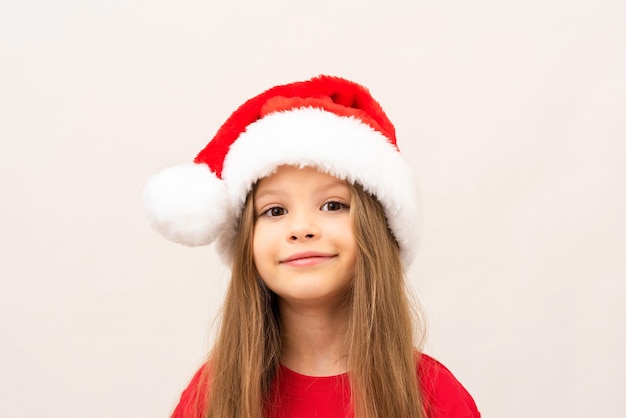 Una hermosa niña con una camiseta roja y un sombrero de Navidad.